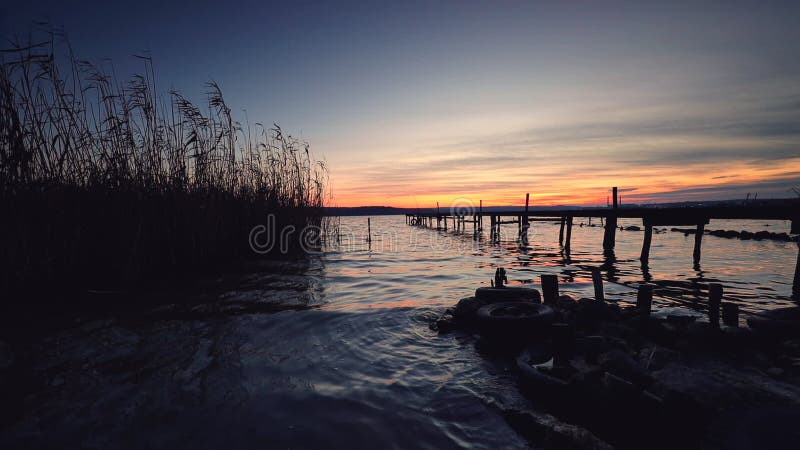 Holz Anlegestelle auf Seesee mit einer Reflexion im Wasser bei Sonnenuntergang