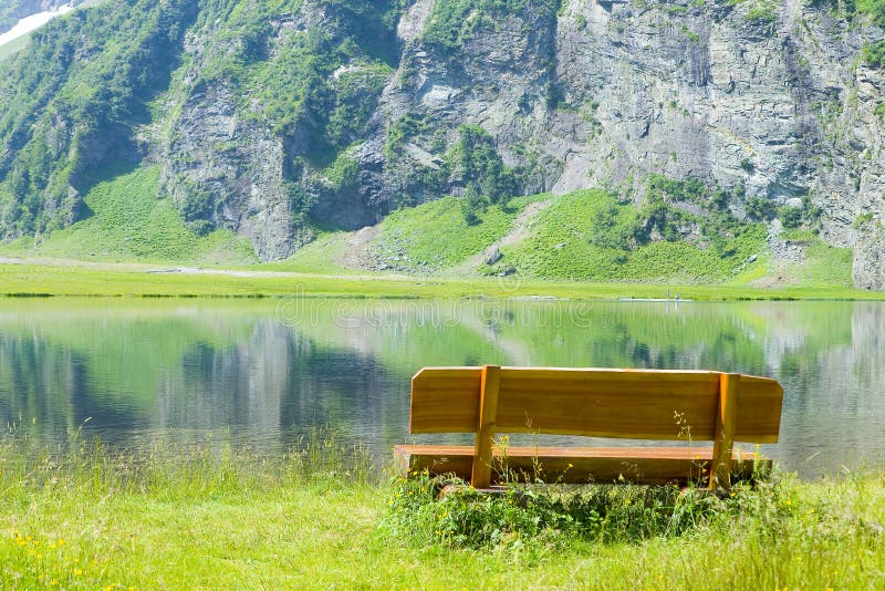 Holzbank vor einem Gebirgssee stockbild Holzbank vor einem Gebirgssee stockbild