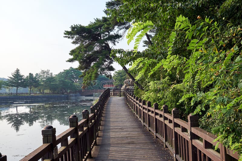 Holzbrücke über dem Uirimji-Reservoir, das zu einen Gazebo übersieht den See in Jechun, Südkorea führt lizenzfreie stockfotos Holzbrücke über dem Uirimji-Reservoir, das zu einen Gazebo übersieht den See in Jechun, Südkorea führt lizenzfreie stockfotos