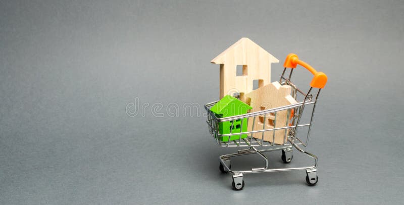 Wooden houses in a Supermarket trolley. The concept of buying a house or apartment. Affordable housing. Profitable and cheap loans for real estate. Buying a home. Mortgage and loan. Wooden houses in a Supermarket trolley. The concept of buying a house or apartment. Affordable housing. Profitable and cheap loans for real estate. Buying a home. Mortgage and loan