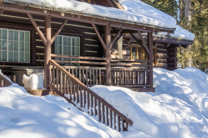 Holzhaus bedeckt im Schnee im Vorfrühlingsholz Alberta Kanada