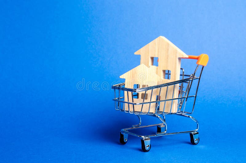 Wooden houses in a trading cart. The concept of buying a house or apartment. Affordable housing. Profitable and cheap loans for real estate. Buying a home. Mortgage and loan. Place for text. Wooden houses in a trading cart. The concept of buying a house or apartment. Affordable housing. Profitable and cheap loans for real estate. Buying a home. Mortgage and loan. Place for text