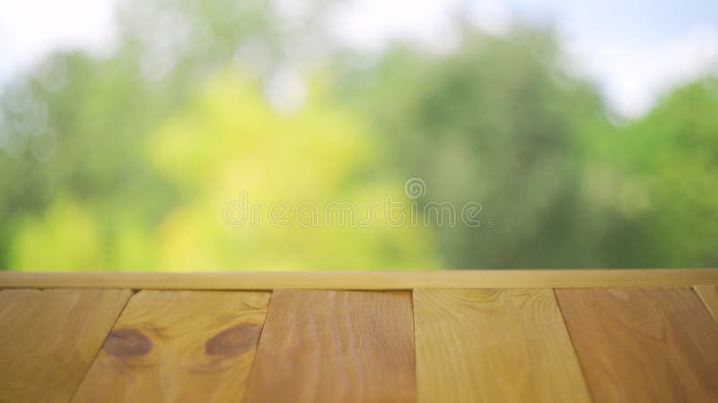 Holztisch auf farbenfrohen, verschwommenen Herbstuntergründen mit blauem Himmel und gelber Baumfoilage stock video