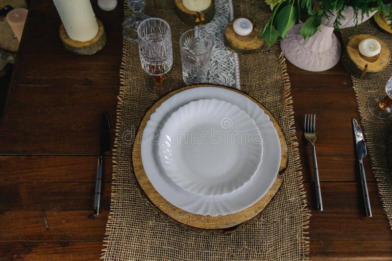 Holztisch eingestellt mit Kerzen, weißer Platte und grauer Serviette stockbilder Holztisch eingestellt mit Kerzen, weißer Platte und grauer Serviette stockbilder
