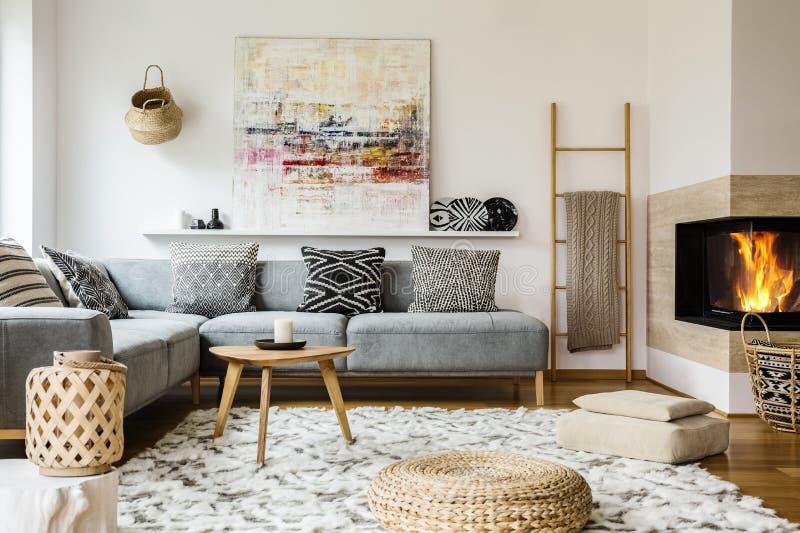 Holztisch nahe bei grauem Ecksofa in warmem Wohnzimmer inte lizenzfreies stockbild