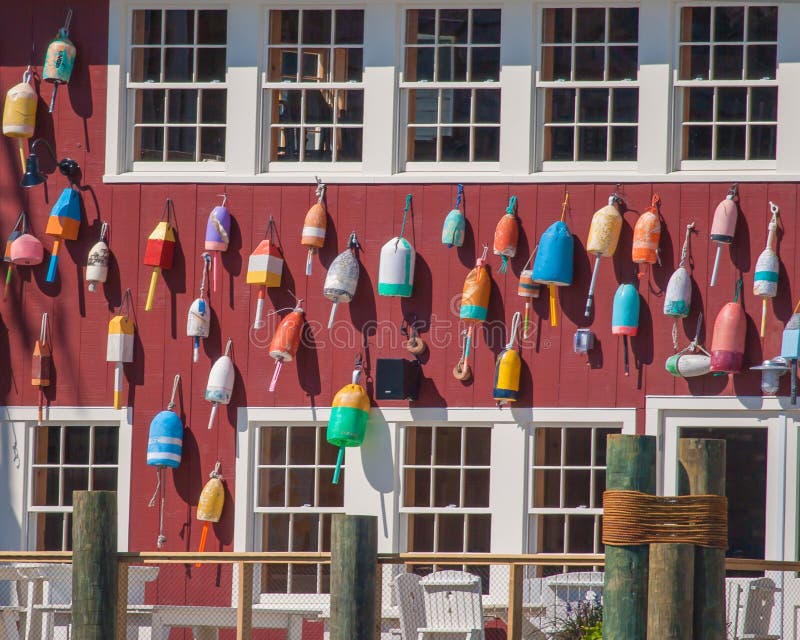 Colorful buoys arranged on the side of a dark red building in Maine. Colorful buoys arranged on the side of a dark red building in Maine