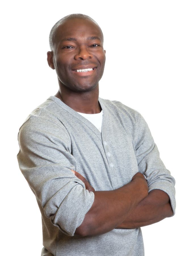 Hombre africano atractivo con los brazos cruzados que se ríe de la cámara fotos de archivo libres de regalías Hombre africano atractivo con los brazos cruzados que se ríe de la cámara fotos de archivo libres de regalías