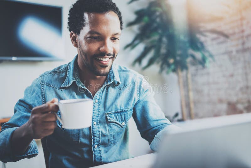 Hombre africano atractivo sonriente que hace la conversación video vía la tableta digital con los socios comerciales mientras que fotos de archivo Hombre africano atractivo sonriente que hace la conversación video vía la tableta digital con los socios comerciales mientras que fotos de archivo