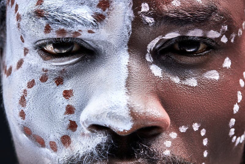 Hombre africano confiado con maquillaje étnico nacional en la cara fotos de archivo
