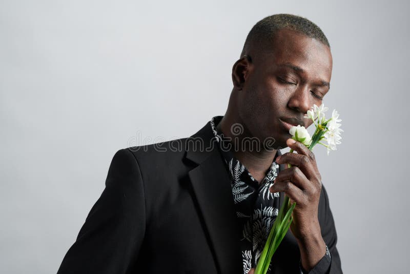 Hombre africano disfrutando de la hermosa flor fotos de archivo