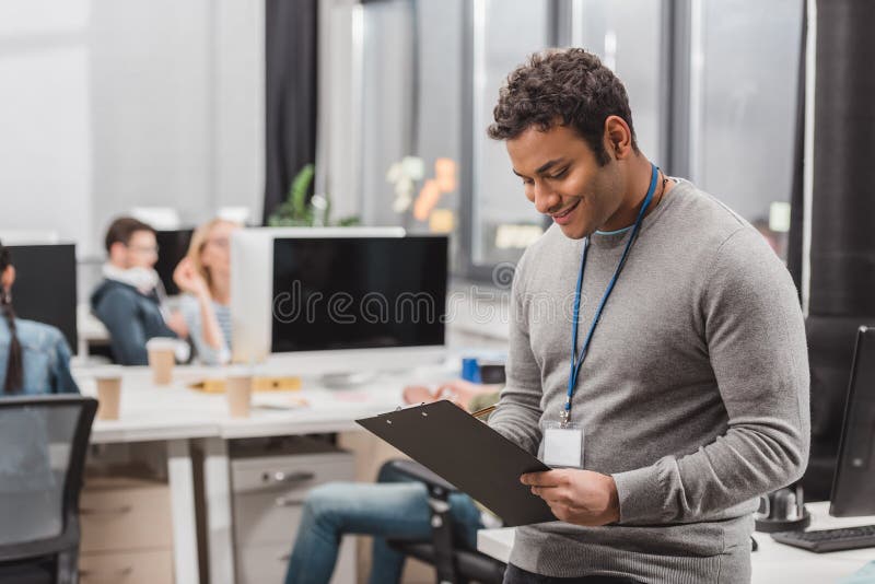 hombre afroamericano feliz con la escritura de la etiqueta del nombre algo en planchette fotografía de archivo libre de regalías hombre afroamericano feliz con la escritura de la etiqueta del nombre algo en planchette fotografía de archivo libre de regalías