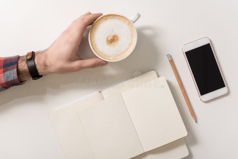 Hombre agradable agradable que sostiene una taza de capuchino imagenes de archivo Hombre agradable agradable que sostiene una taza de capuchino imagenes de archivo