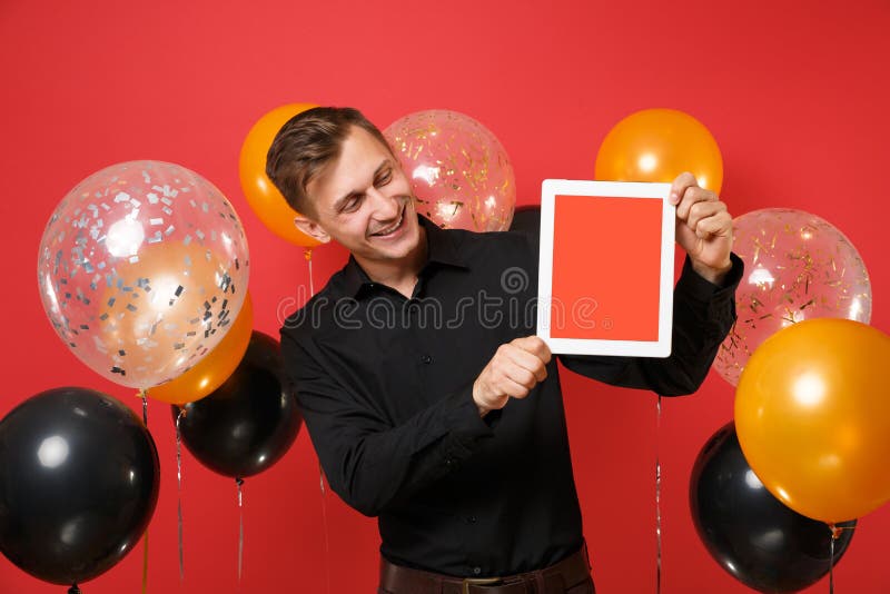 Hombre alegre en la camisa clásica que mira en el ordenador de la PC de la tableta con la pantalla vacía negra del espacio en bla fotografía de archivo Hombre alegre en la camisa clásica que mira en el ordenador de la PC de la tableta con la pantalla vacía negra del espacio en bla fotografía de archivo