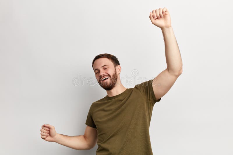 Hombre alegre positivo en la camiseta verde que se divierte en el estudio imágenes de archivo libres de regalías Hombre alegre positivo en la camiseta verde que se divierte en el estudio imágenes de archivo libres de regalías