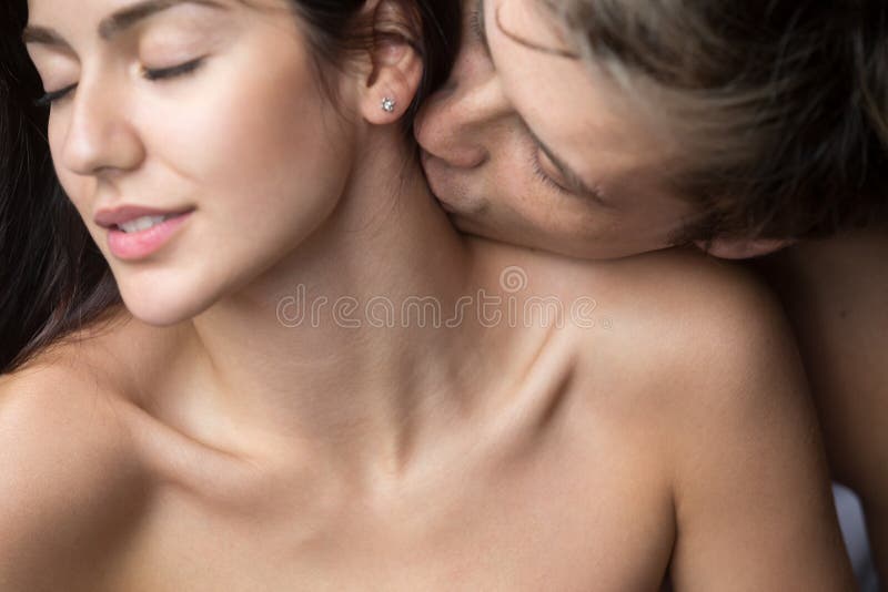 Hombre apasionado que besa a la mujer en cuello que disfruta de foreplay