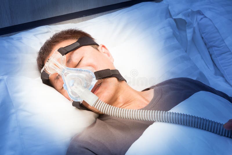 Hombre asiático con apnea del sueño usando la máquina cpap