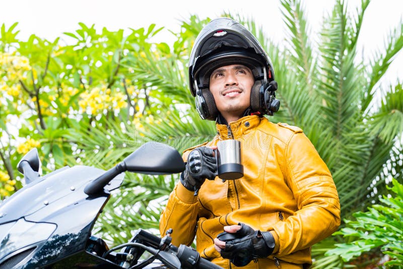 Hombre asiático en la motocicleta con el casco imagen de archivo Hombre asiático en la motocicleta con el casco imagen de archivo