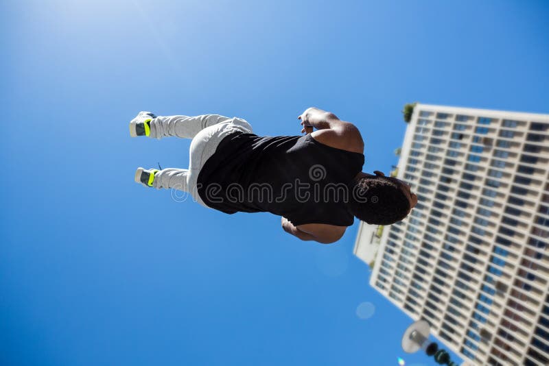 Hombre atlético que hace salto mortal hacia atrás en la ciudad fotos de archivo Hombre atlético que hace salto mortal hacia atrás en la ciudad fotos de archivo