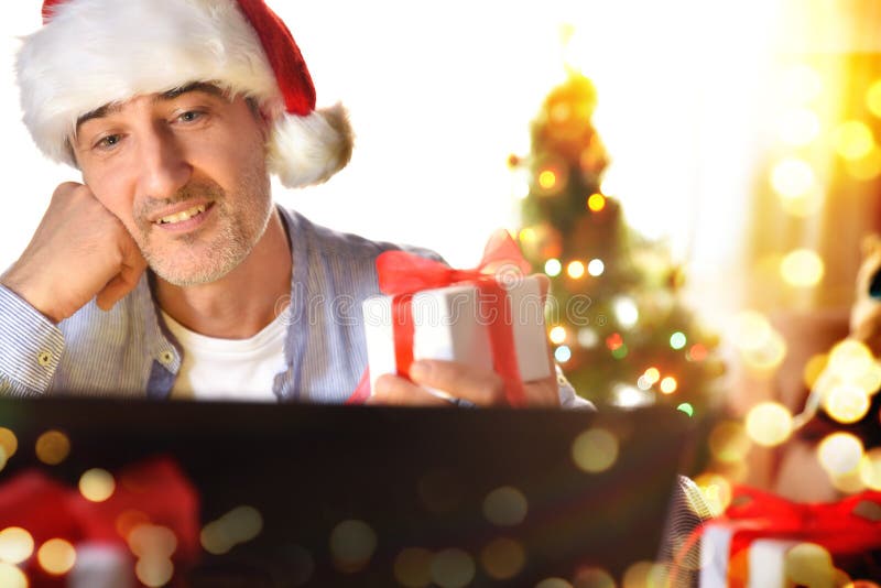Hombre autoabsorto mirando un regalo de navidad con deseo fotos de archivo libres de regalías