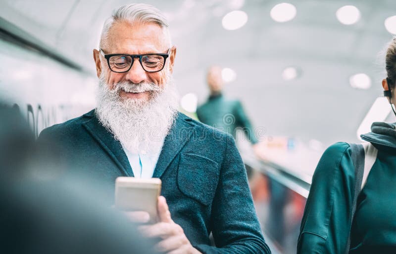 Hombre barbudo de Hipster usando teléfono inteligente móvil en ascensores de centros comerciales - Vieja de moda compartiendo con fotos de archivo libres de regalías