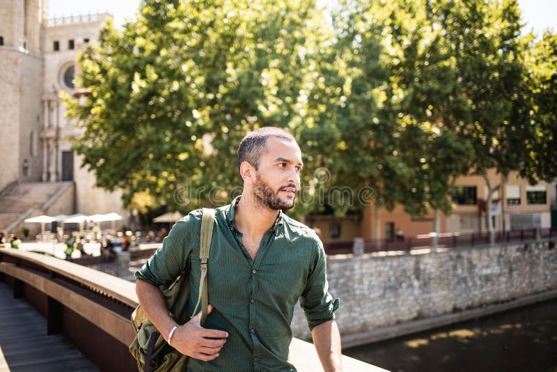 Hombre barbudo hermoso que se coloca en el puente y que mira lejos foto de archivo Hombre barbudo hermoso que se coloca en el puente y que mira lejos foto de archivo