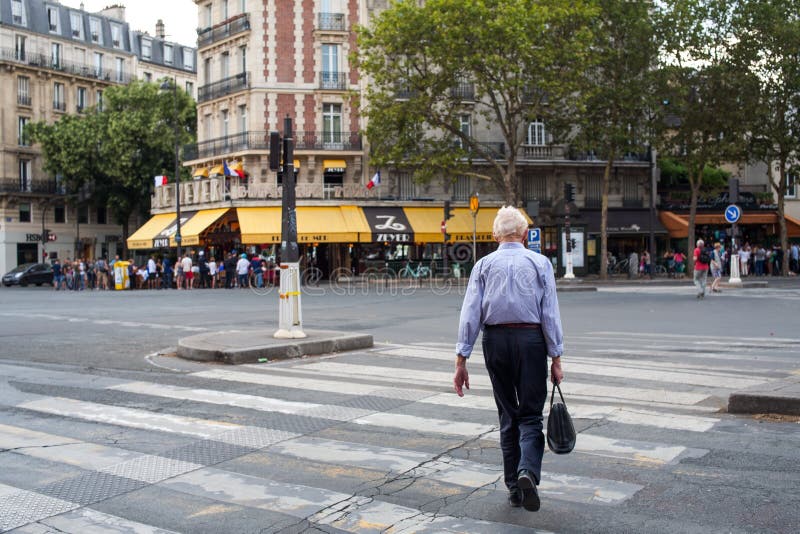 hombre Blanco-cabelludo que cruza la calle en camino peatonal de la cebra en París del sur fotografía de archivo libre de regalías hombre Blanco-cabelludo que cruza la calle en camino peatonal de la cebra en París del sur fotografía de archivo libre de regalías