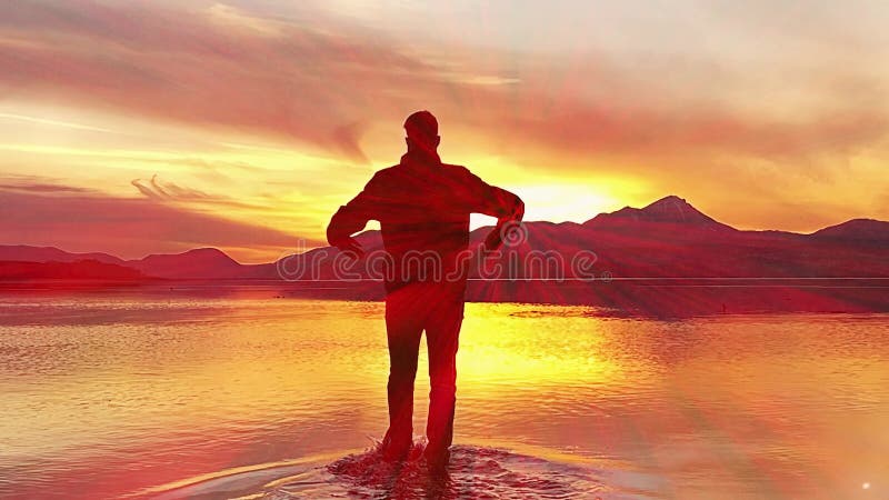 Hombre caminando sobre el agua con el hombre atardecer con los brazos extendidos mirando la vista trasera del sol. metrajes