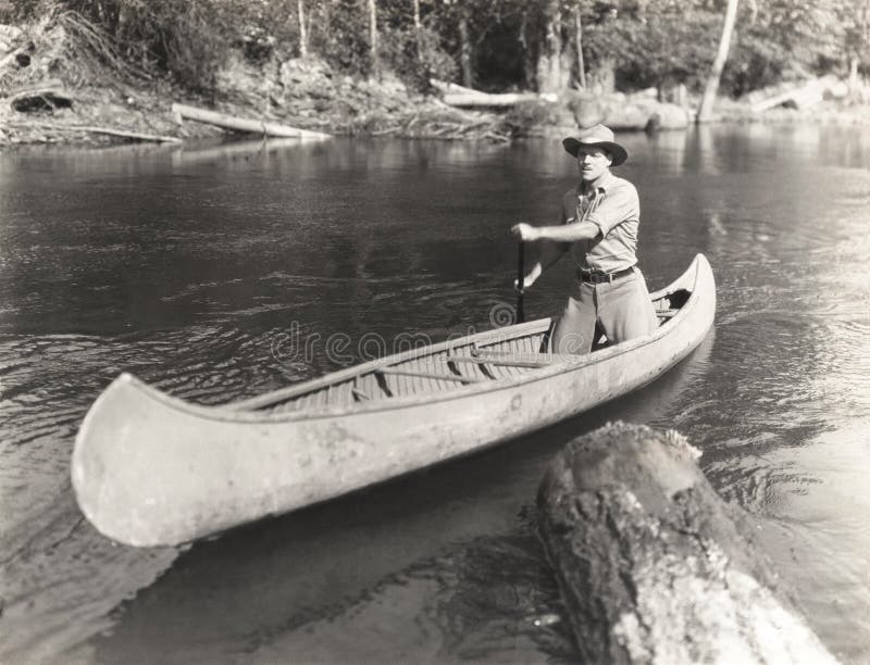 Hombre canoeing abajo del río fotografía de archivo Hombre canoeing abajo del río fotografía de archivo