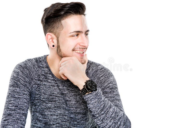 Hombre casual joven que presenta con sonrisa del diente en el piso mientras que mirada fotografía de archivo libre de regalías Hombre casual joven que presenta con sonrisa del diente en el piso mientras que mirada fotografía de archivo libre de regalías