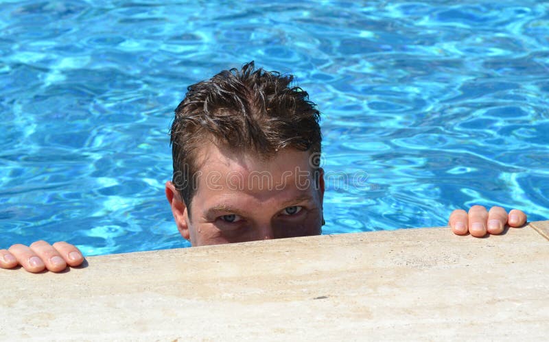 Hombre caucásico hermoso en la piscina que mira la cámara imagenes de archivo Hombre caucásico hermoso en la piscina que mira la cámara imagenes de archivo