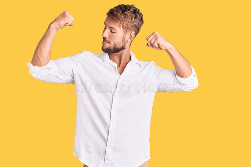 Hombre caucásico joven con ropa casual que muestra los músculos de los brazos sonriendo orgulloso fotografía de archivo libre de regalías