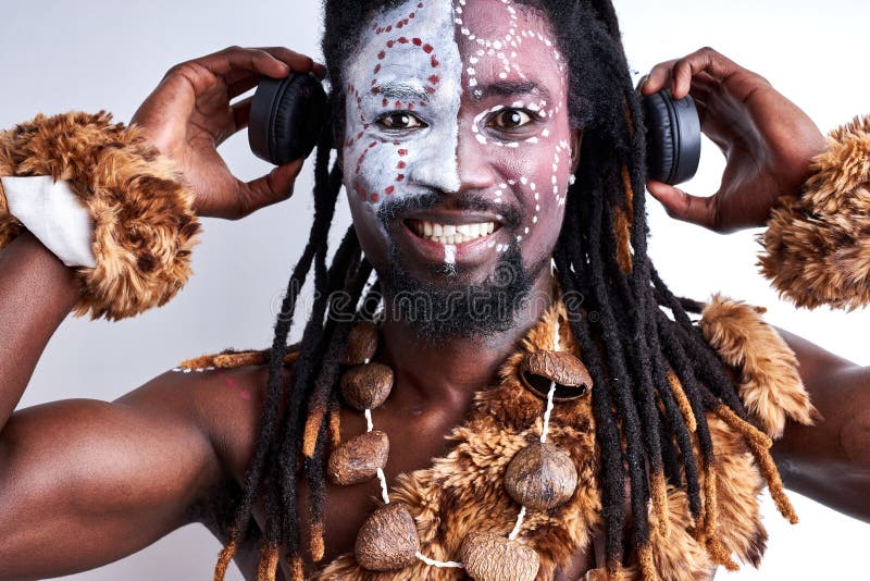 Hombre chamánico negro feliz usando auriculares imagenes de archivo