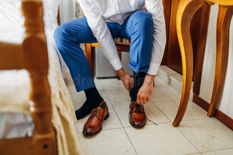 Varios descanso Automatización Hombre Con Camisa Blanca Y Pantalones Azules Atando Sus Zapatos En Una  Silla. Cerrar Imagen de archivo - Imagen de azul, calcetines: 234308773