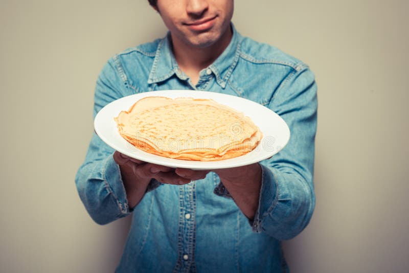 Hombre con la pila de crepes fotografía de archivo Hombre con la pila de crepes fotografía de archivo
