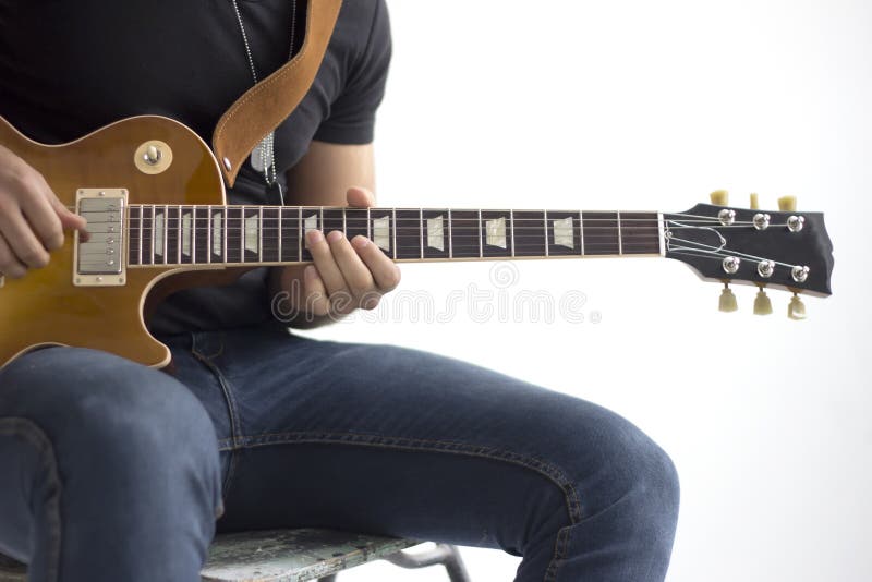 Hombre con la sentada de la guitarra eléctrica aislado sobre blanco imagen de archivo Hombre con la sentada de la guitarra eléctrica aislado sobre blanco imagen de archivo