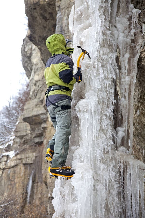 Escalador de hielo con crampones en botas de montaña - fotografía de stock