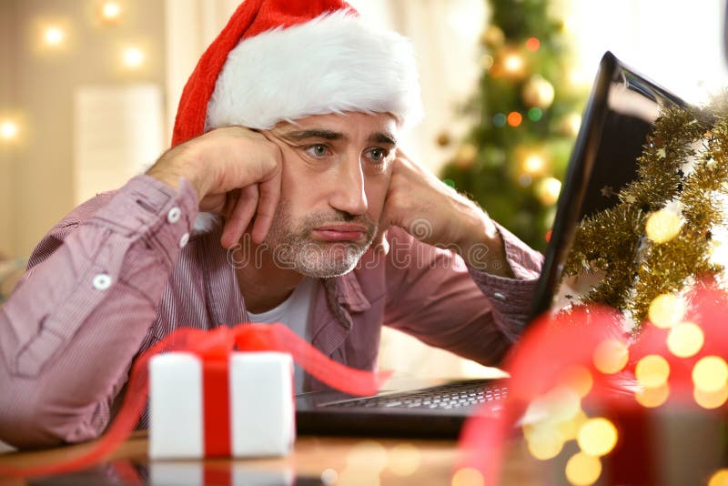 Hombre con navidad que mira la pantalla del portátil decepcionado fotografía de archivo