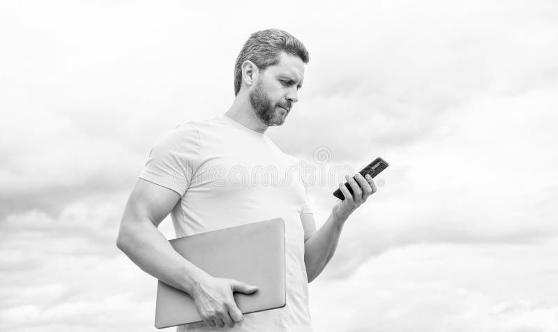 Hombre con pc charlando en un smartphone sobre fondo.