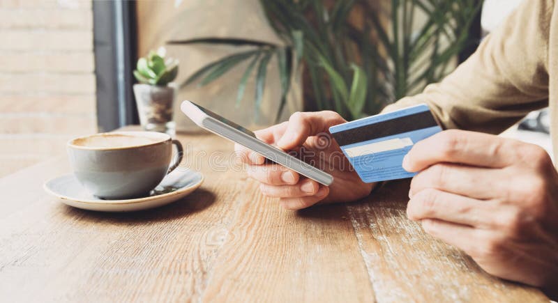 Hombre con tarjeta de crédito y usando un smartphone en un café viajar en línea comprar ecommerce banca electrónica finanzas y fre