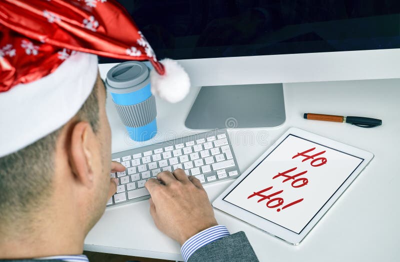 Hombre con una tableta con el texto ho ho ho en su oficina imagen de archivo