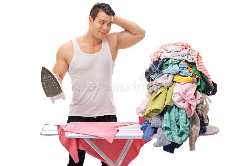 Hombre confuso que plancha una pila de ropa foto de archivo Hombre confuso que plancha una pila de ropa foto de archivo