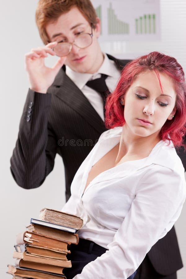 Hombre CONTRA molestias de la mujer en lugar de trabajo imágenes de archivo libres de regalías Hombre CONTRA molestias de la mujer en lugar de trabajo imágenes de archivo libres de regalías