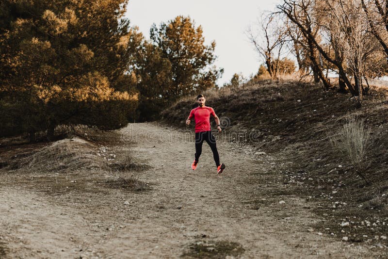 Hombre corriente del deporte en funcionamiento del rastro del campo a través Entrenamiento masculino apto del ejercicio del corre imagenes de archivo Hombre corriente del deporte en funcionamiento del rastro del campo a través Entrenamiento masculino apto del ejercicio del corre imagenes de archivo