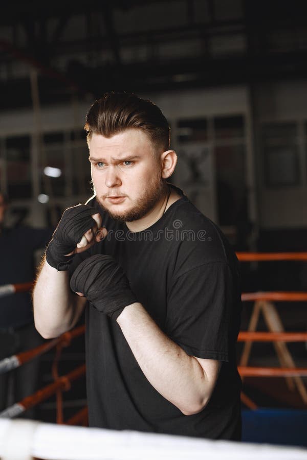 Hombre con guantes. boxeador en ropa deportiva. chico con barba.