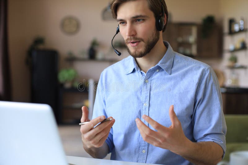 Hombre de confianza usando auriculares para hablar y ver formación en webinar sobre negocios escuchando conferencias