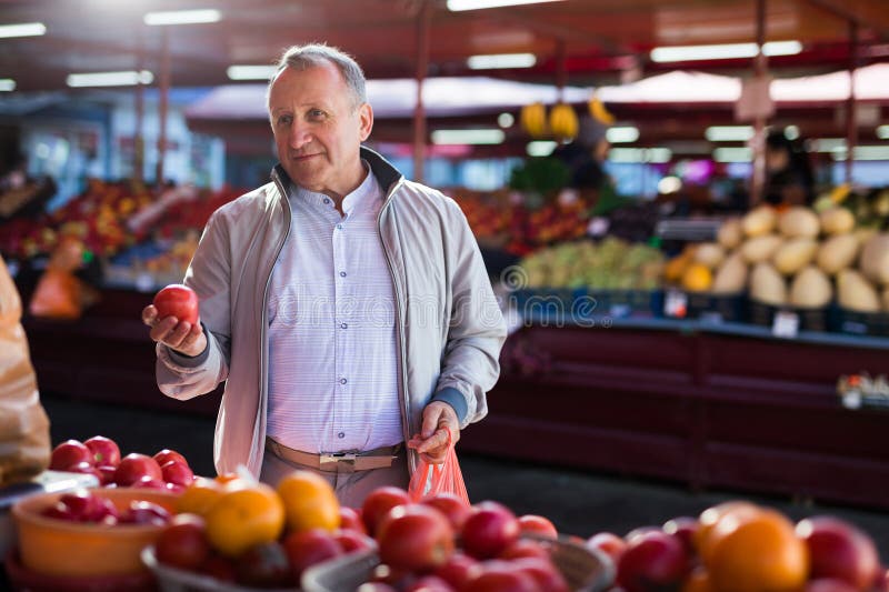 Hombre de edad media comprando tomates imágenes de archivo libres de regalías