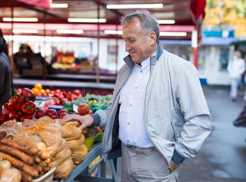 Hombre de edad media comprando verduras imagen de archivo libre de regalías