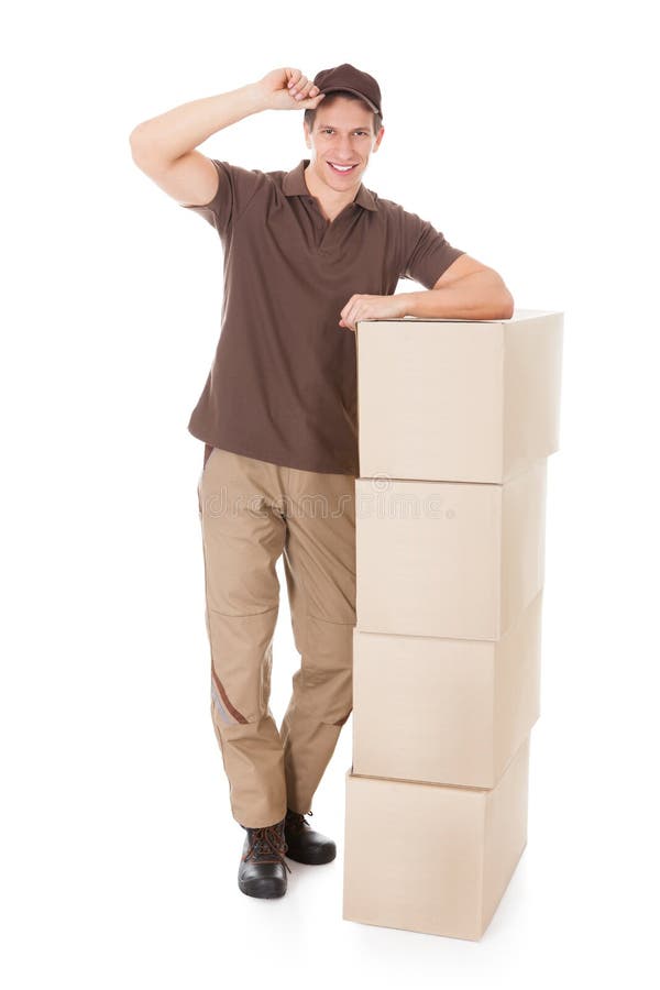 Hombre de entrega joven que se inclina en una pila de cajas foto de archivo libre de regalías Hombre de entrega joven que se inclina en una pila de cajas foto de archivo libre de regalías
