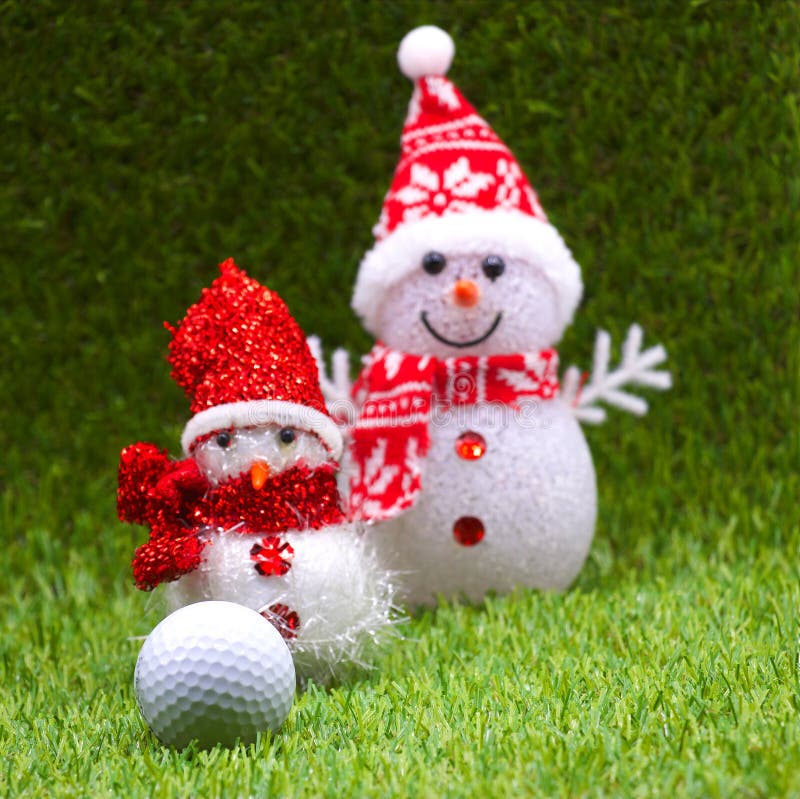 Golf ball with Snow man and Christmas ornament on green grass. Golf ball with Snow man and Christmas ornament on green grass