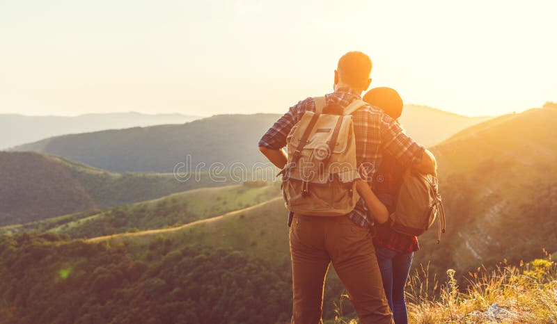 Hombre de los pares y turista felices de la mujer en la parte superior de la montaña en la puesta del sol imagenes de archivo